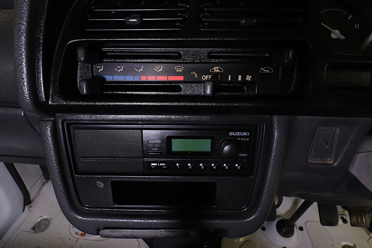 White 1991 Suzuki Carry Dump Bed 4x4 Kei Truck, heater controls and radio, for sale at Duncan Imports in Christiansburg, VA