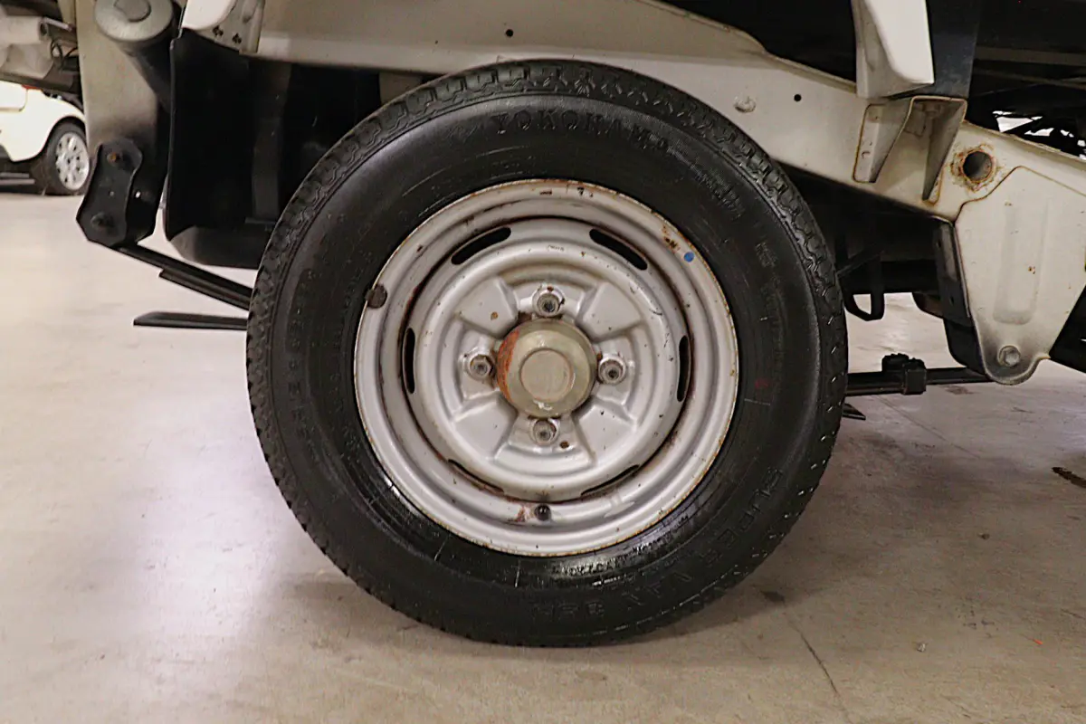 White 1991 Suzuki Carry Dump Bed 4x4 Kei Truck, rear wheel and tire, for sale at Duncan Imports in Christiansburg, VA