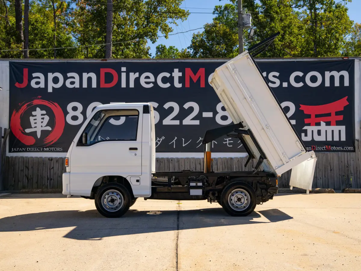 White 1994 Subaru Sambar Dump Bed 4x4 Kei Truck, side view with raised dump bed, for sale at Japan Direct Motors in Irmo, SC