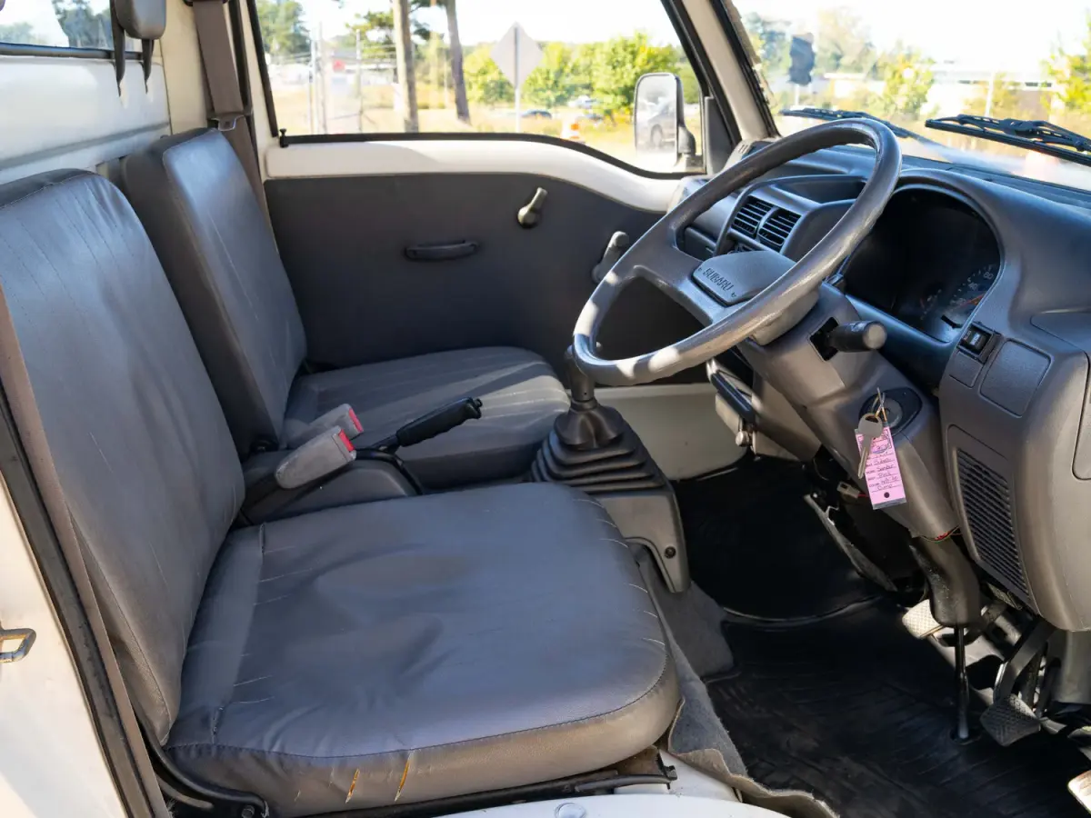 White 1994 Subaru Sambar Dump Bed 4x4 Kei Truck, cab interior with seats, for sale at Japan Direct Motors in Irmo, SC