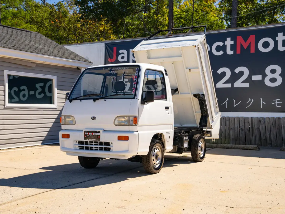 White 1994 Subaru Sambar Dump Bed 4x4 Kei Truck, front three-quarter view with raised dump bed, for sale at Japan Direct Motors in Irmo, SC
