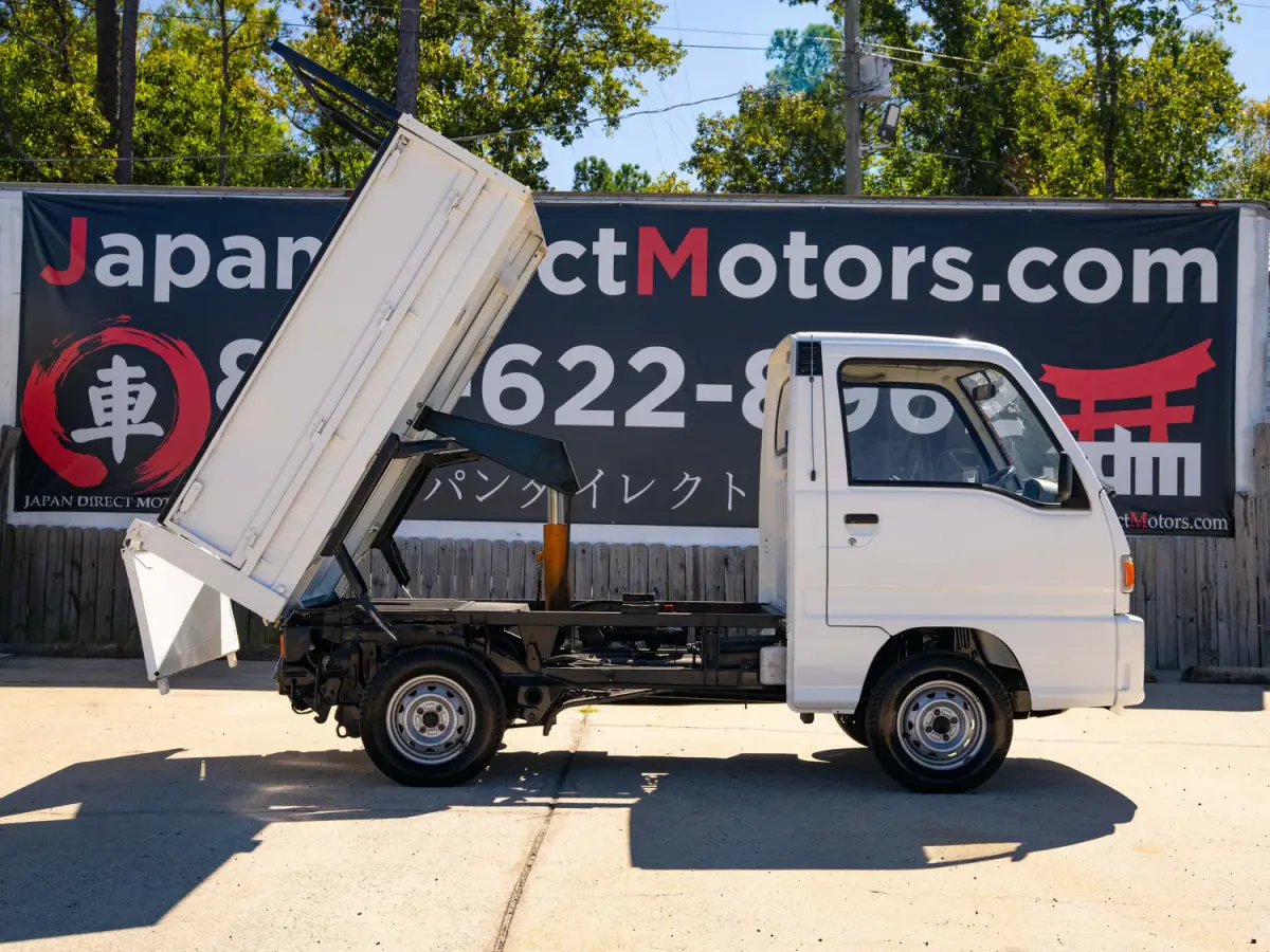 White 1994 Subaru Sambar Dump Bed 4x4 Kei Truck, side view with raised dump bed, for sale at Japan Direct Motors in Irmo, SC