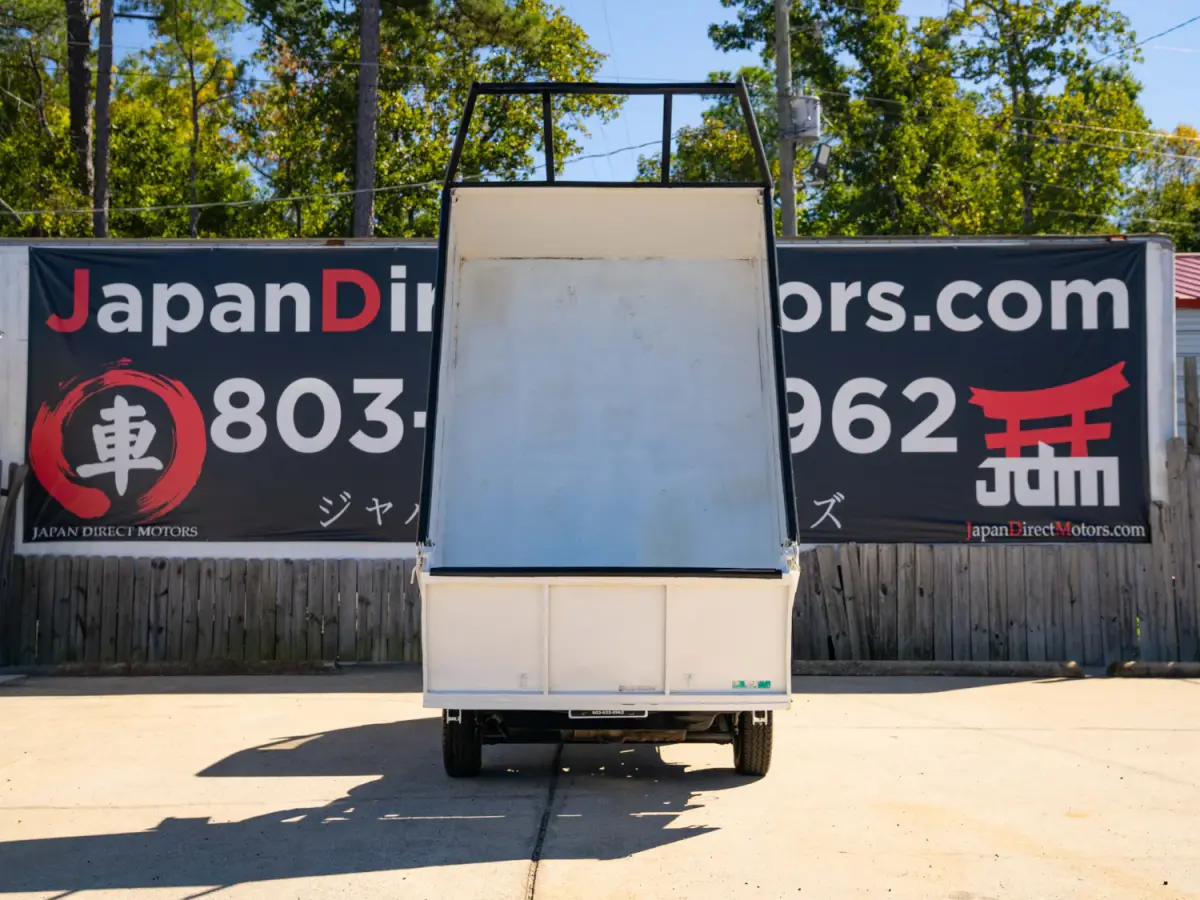 White 1994 Subaru Sambar Dump Bed 4x4 Kei Truck, rear view with raised dump bed, for sale at Japan Direct Motors in Irmo, SC