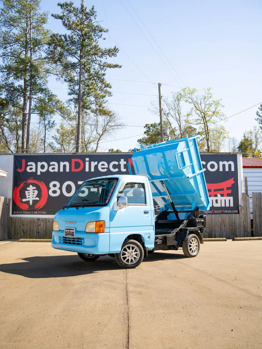 1999 Subaru Sambar Dump Bed, a blue Kei Truck, for sale at Japan Direct Motors in Irmo, SC (photo 1 of 12)