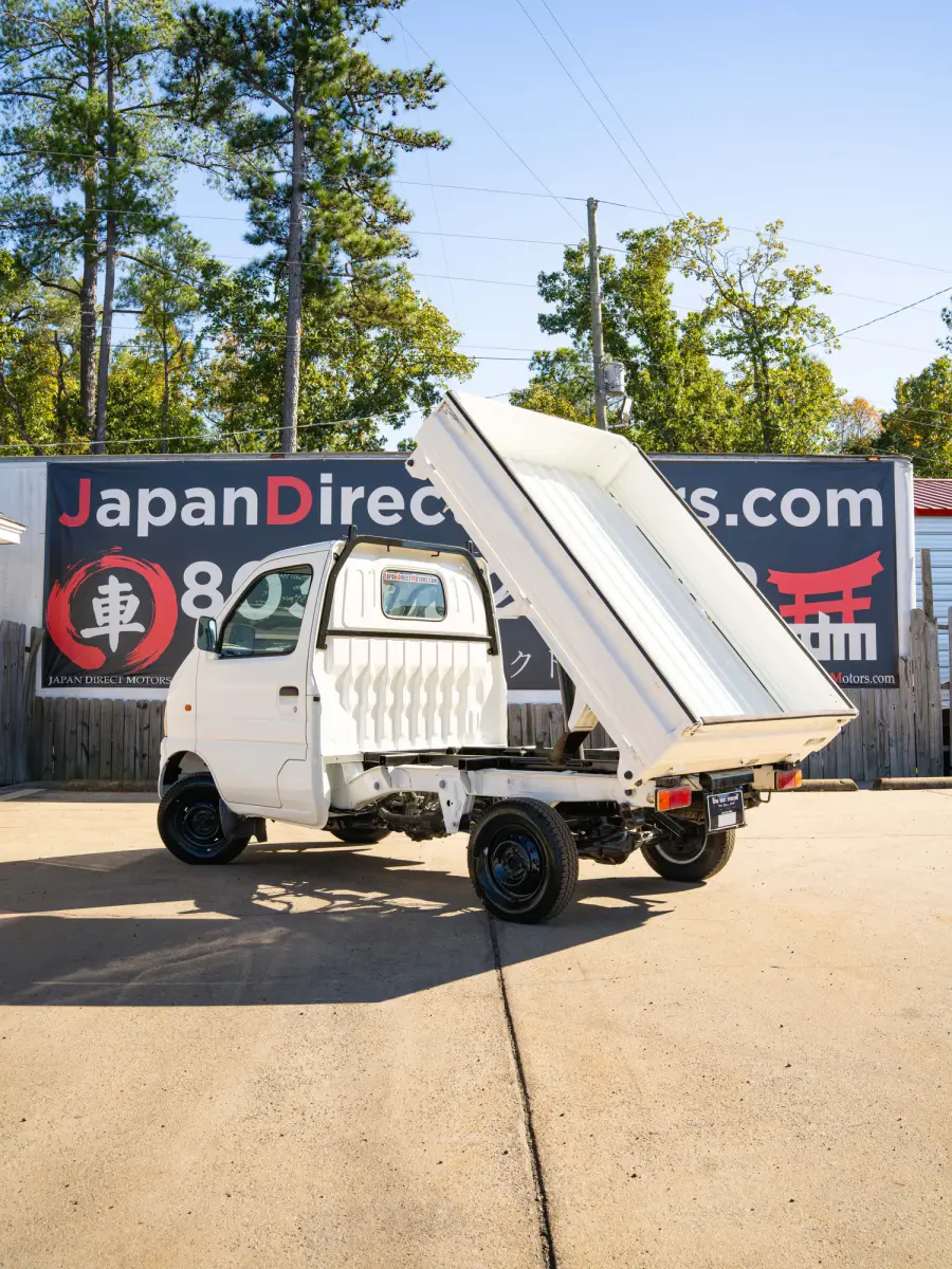 White 2000 Suzuki Carry Dump Bed 4x4 Kei Truck, rear three-quarter view with raised dump bed, for sale at Japan Direct Motors in Irmo, SC