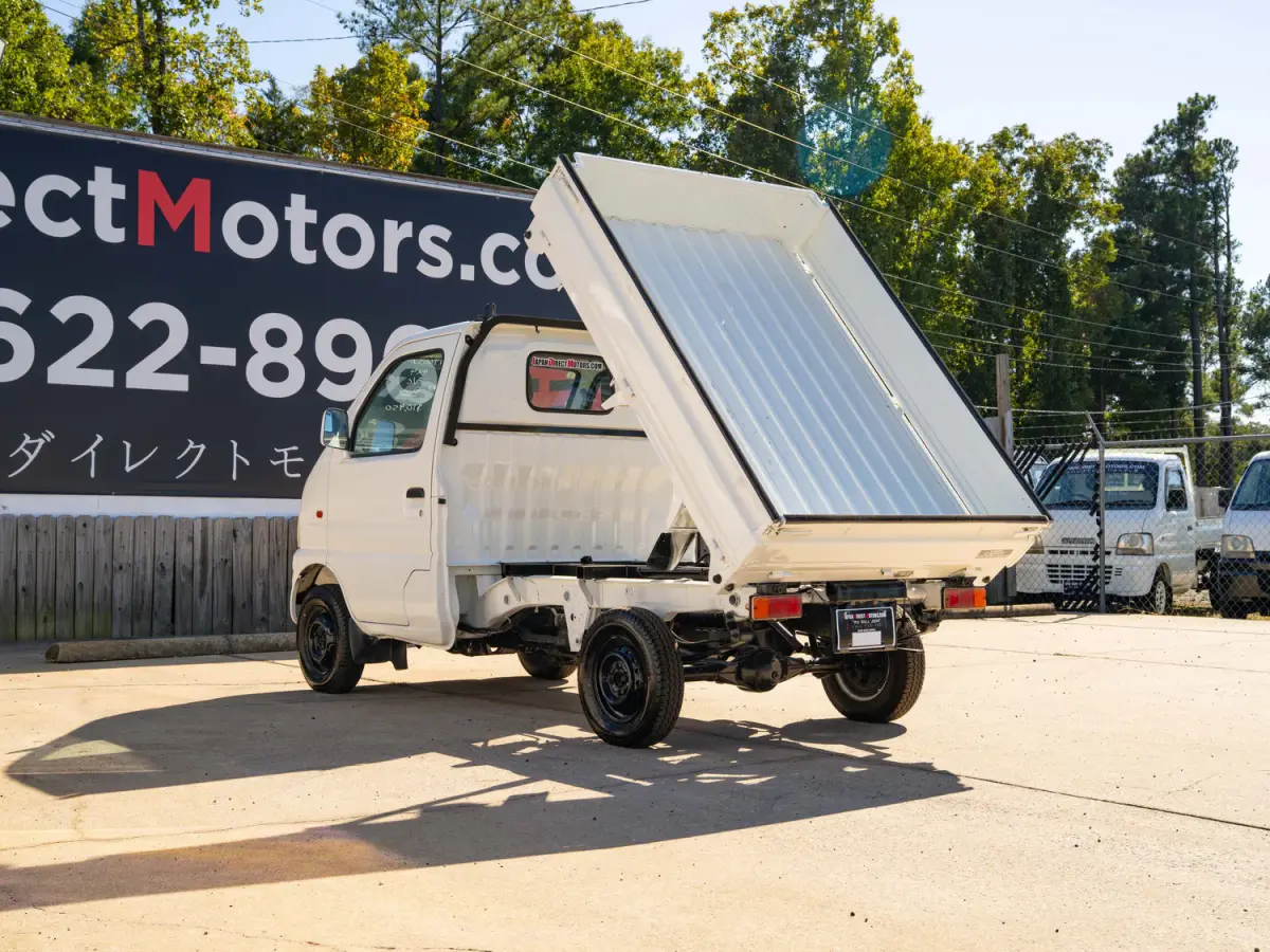 White 2000 Suzuki Carry Dump Bed 4x4 Kei Truck, rear three-quarter view with raised dump bed, for sale at Japan Direct Motors in Irmo, SC